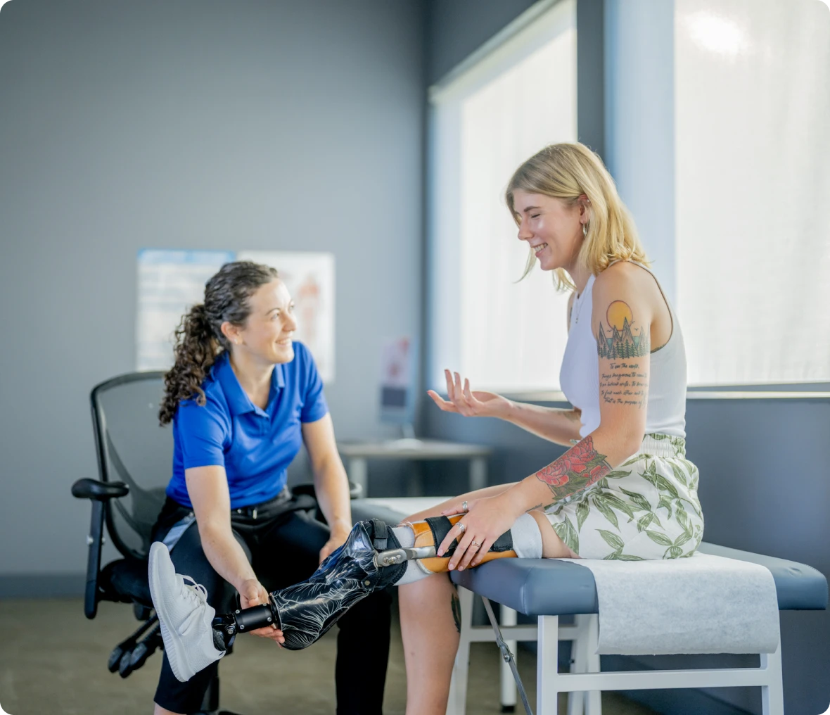Therapist assisting woman with prosthetic leg.